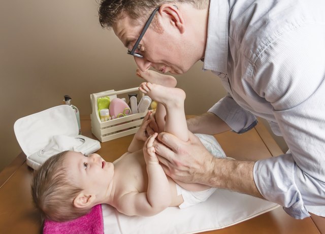 Father playing with baby feet after change diaper