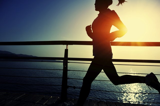 healthy lifestyle asian woman running at wooden boardwalk seaside