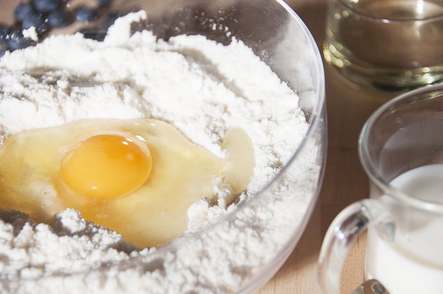 Baking ingredients, flour, egg, milk, oil and blueberries