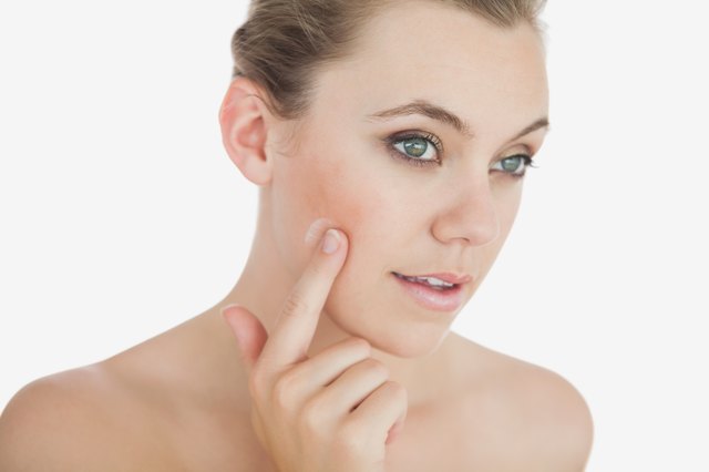 Woman applying cream on face
