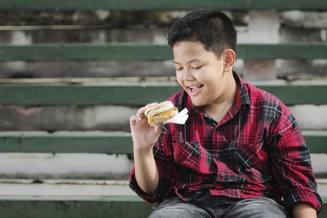 asian boy holding a sandwich