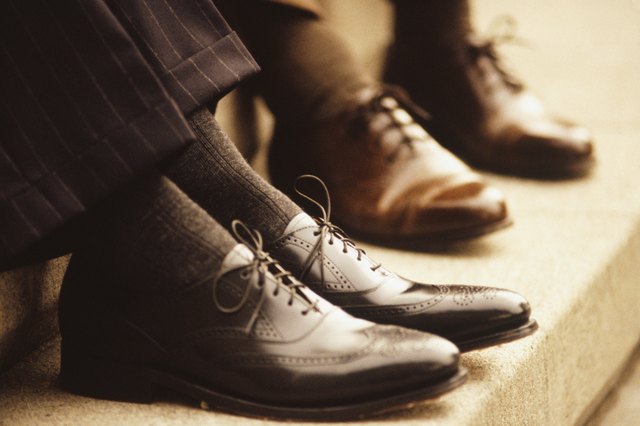 Two businessmen sitting on steps, Close-up of feet