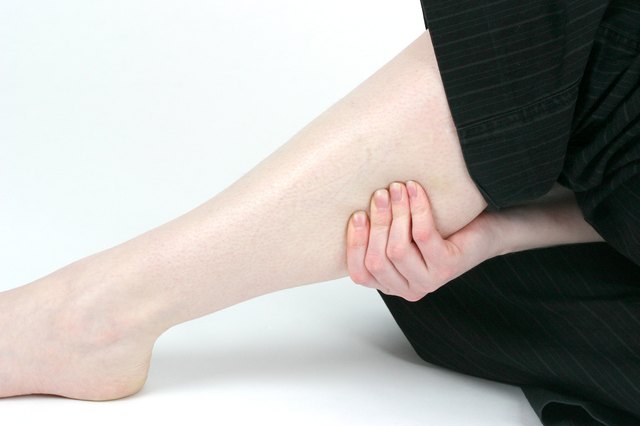 Woman holding sore muscle on leg