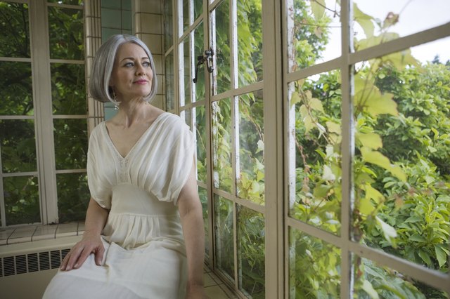 Mature woman sitting by garden window