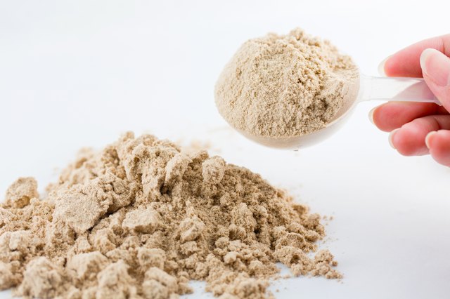 The hand raise a spoon measure Whey protein.