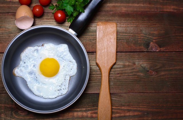 Pan of fried egg, with cherry-tomatoes and parsley