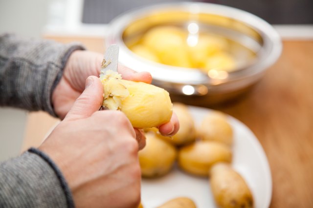 woman peeling potatoes in the kitchen