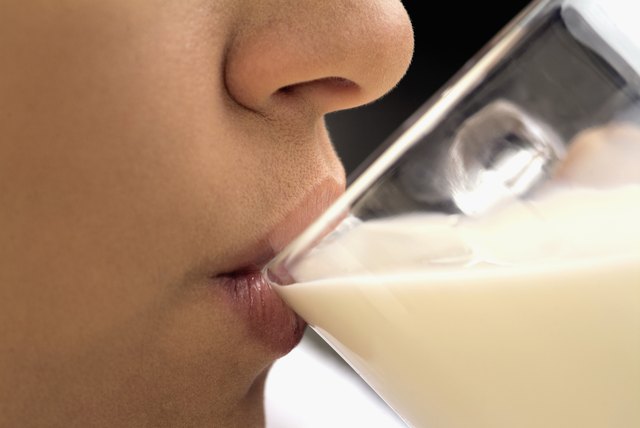 Woman drinking milk, close-up, part of