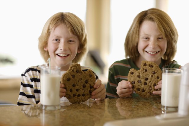 Boys having milk and cookies at table