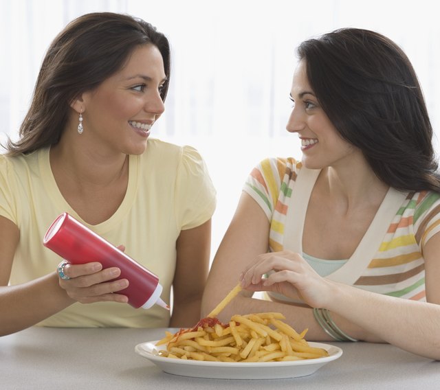 Two young women eating french fries
