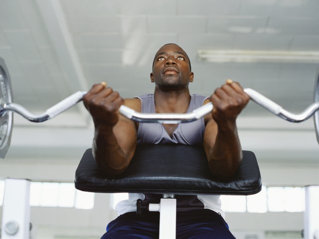 Low angle view of a mid adult man exercising in the gym with weights