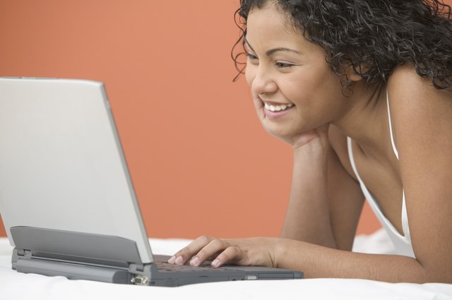 Side view of reclining teenage girl with laptop
