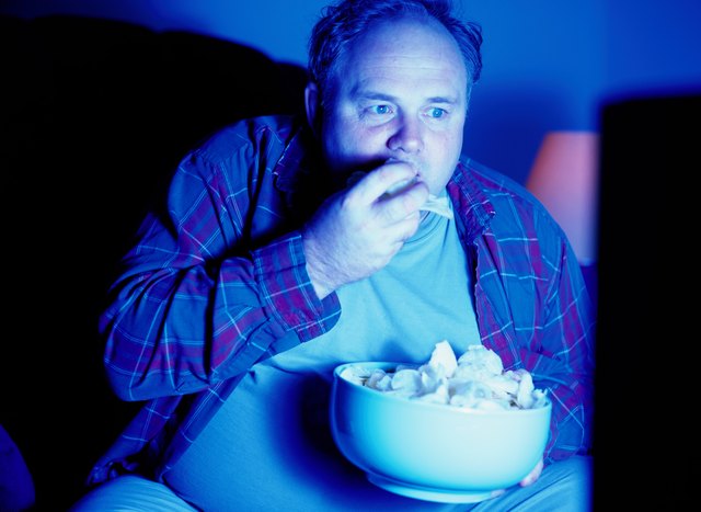 Man Eating Potato Chips and Watching Television