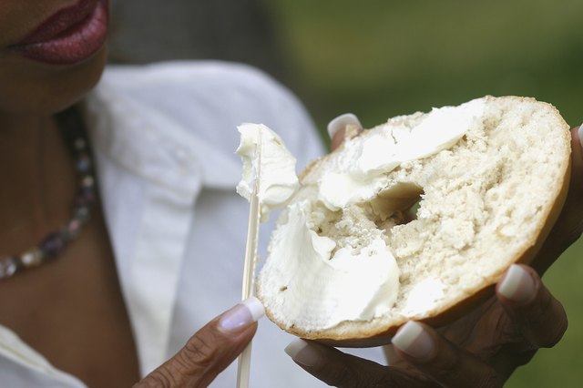 Close-up of a young woman holding a bagel