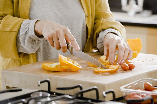 Woman preparing bell peppers on cutting board