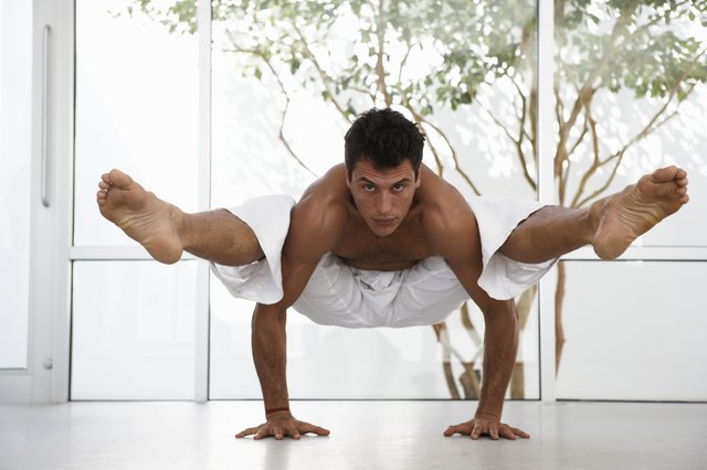 Man in yoga position balancing body off floor, portrait