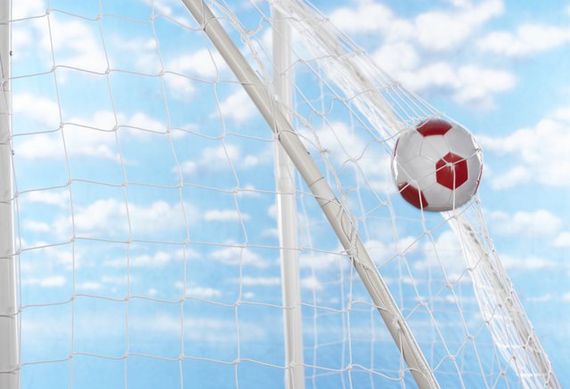 Soccer ball hitting back of net of goal