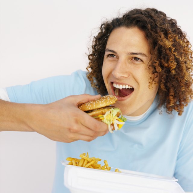 Young man eating a burger and fries