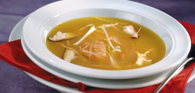 Mushroom soup with bouillon in bowl, close-up