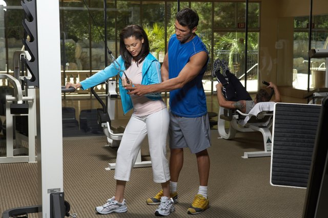Man instructing to woman in gym