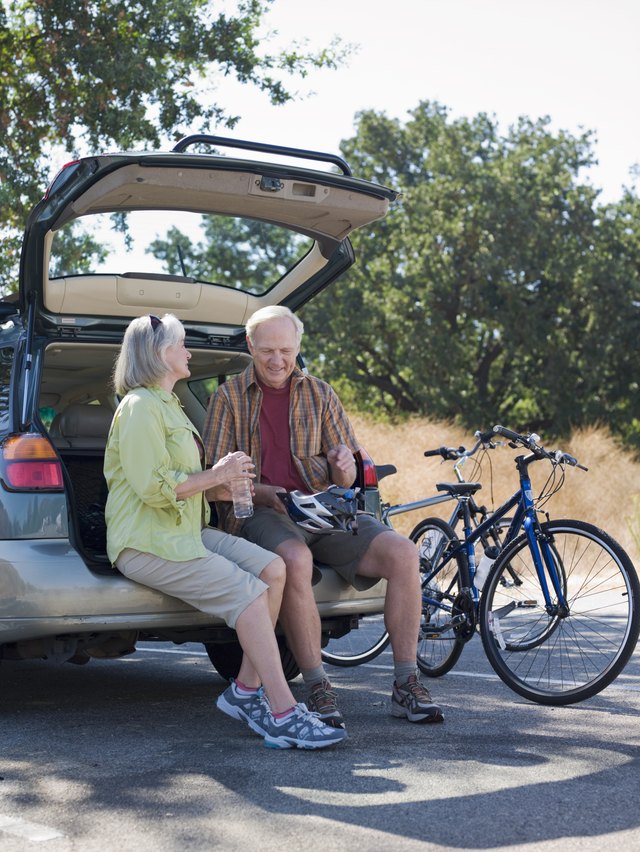 Mature couple sitting on back of car
