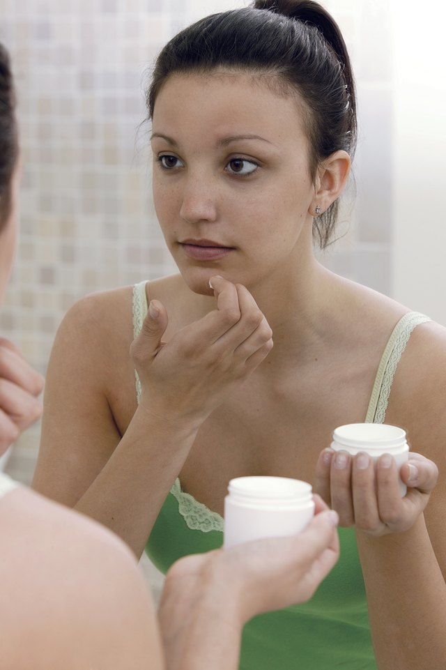 Teenage girl using face cream