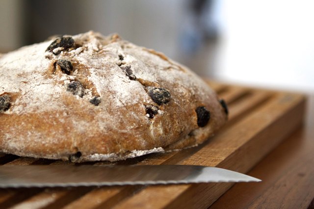 Loaf of sourdough bread with raisins on a wooden board