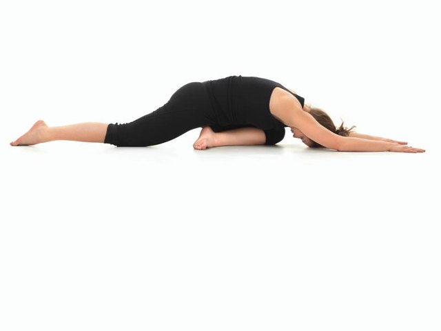 young girl in yoga pose, side view, dressed in black, on white background