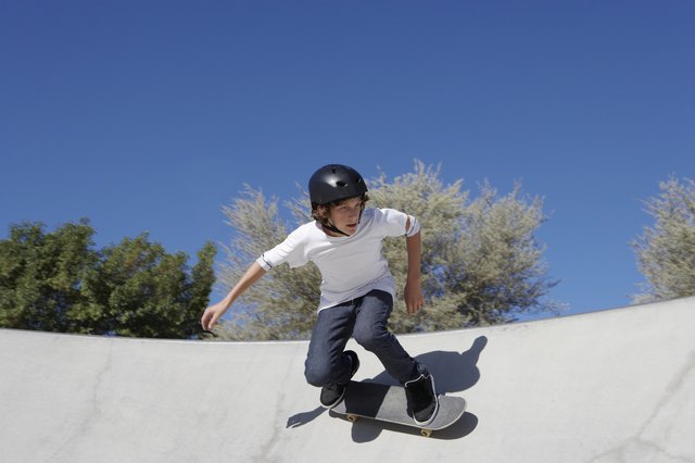 Teenage boy (16-17) skateboarding at skate park