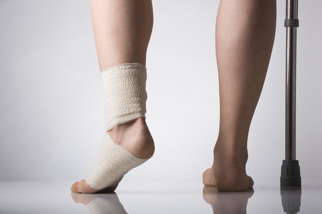Person wearing support bandage and holding crutch