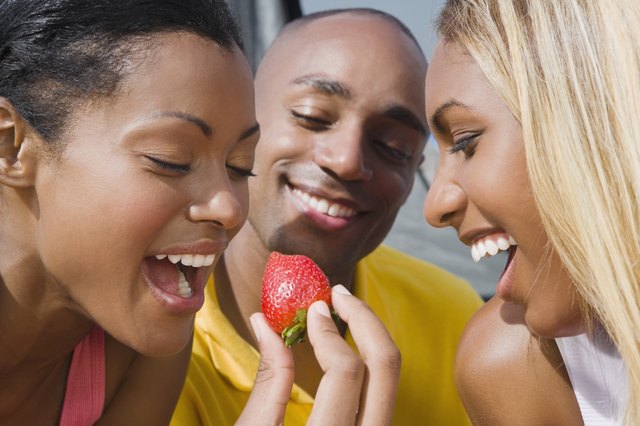 Hispanic woman eating strawberry
