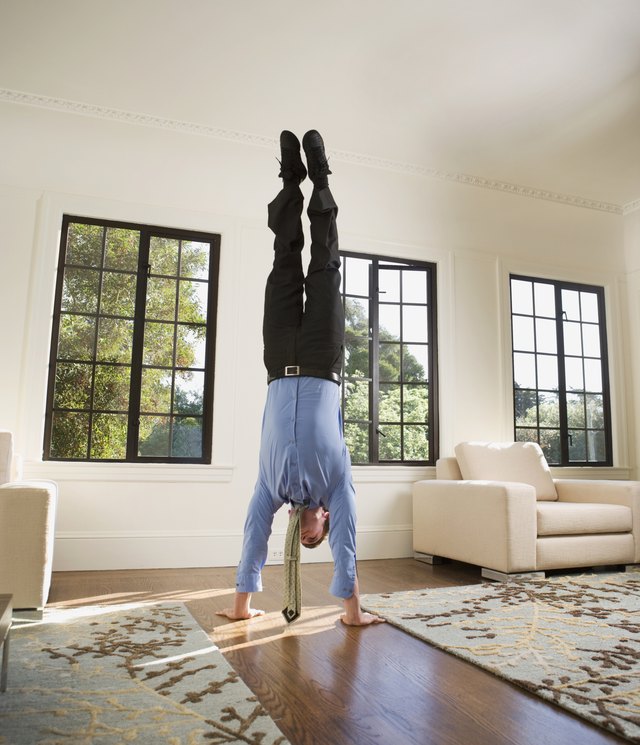 Hispanic businessman doing handstand