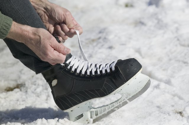 Close up of man lacing ice skate