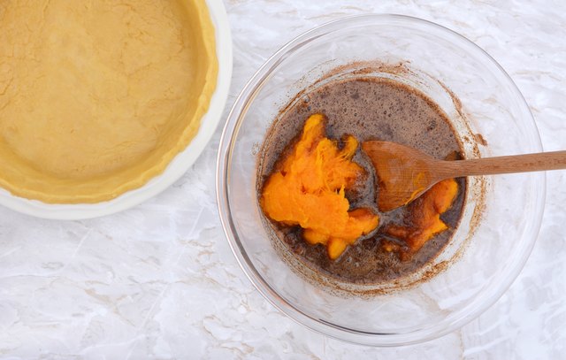 Pastry case with bowl of pie filling and pureed pumpkin