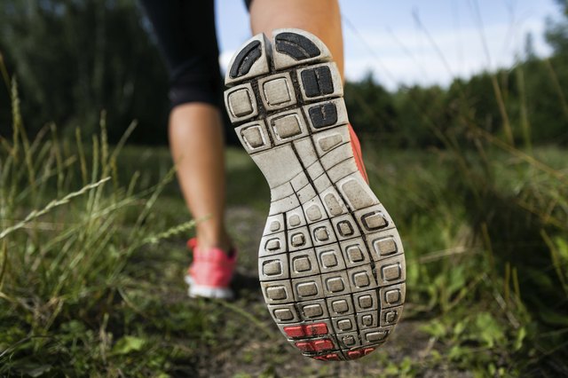 Woman and running shoes in forest, exercising outdoors