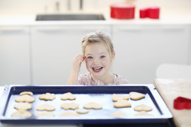 Girl with cookie dough on baking tray