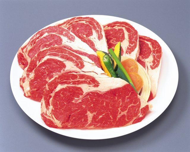 Sirloin steaks with vegetables on plate, high angle view, close up