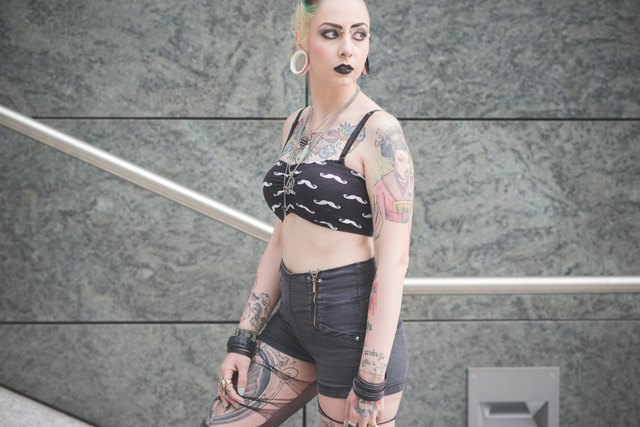 Portrait of young female tattooed punk on subway stairs