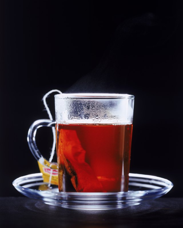 Tea cup with tea bag on black background