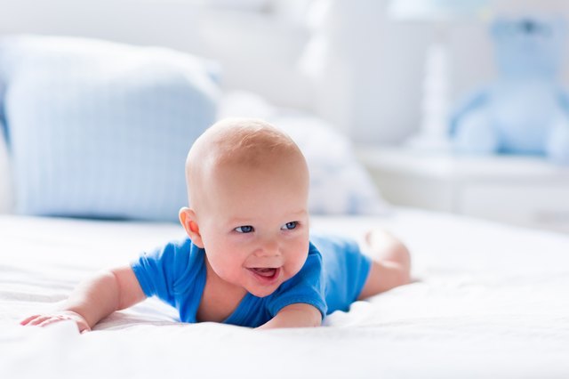Baby boy in white sunny bedroom