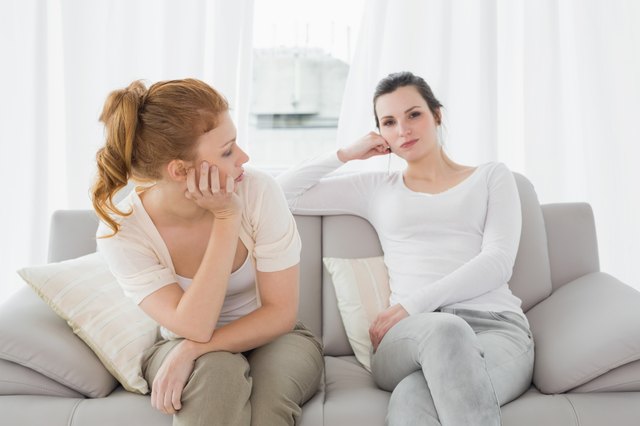 Unhappy friends not talking after argument on the couch