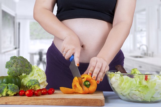 Pregnant woman cooking salad 1