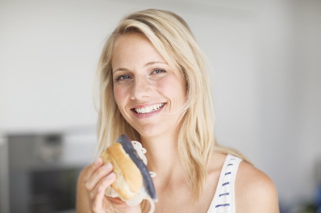 Portrait of mid adult woman holding fish sandwich