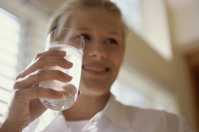 Low angle view of a young woman holding a glass of water