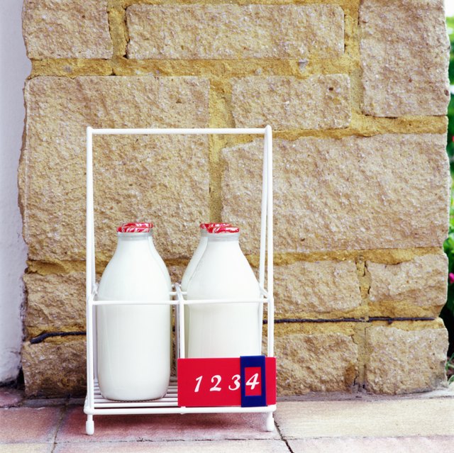 Four milk bottles in holder, close-up