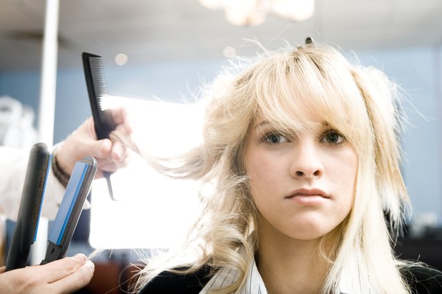 Woman getting her hair straightened at a salon