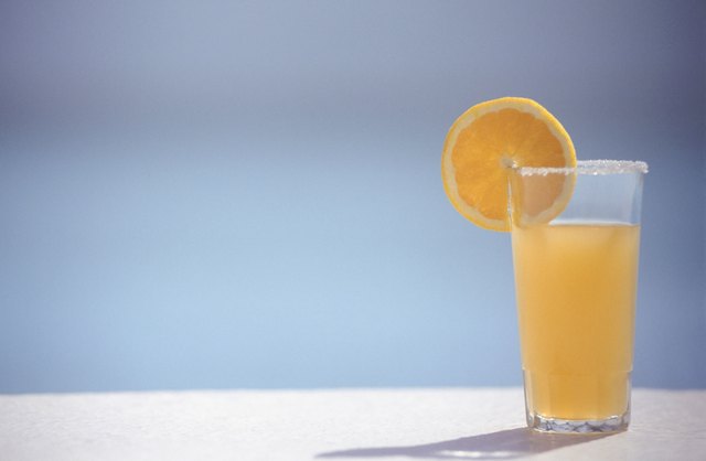 Orange juice in glass with slice of orange, ground view, copy space