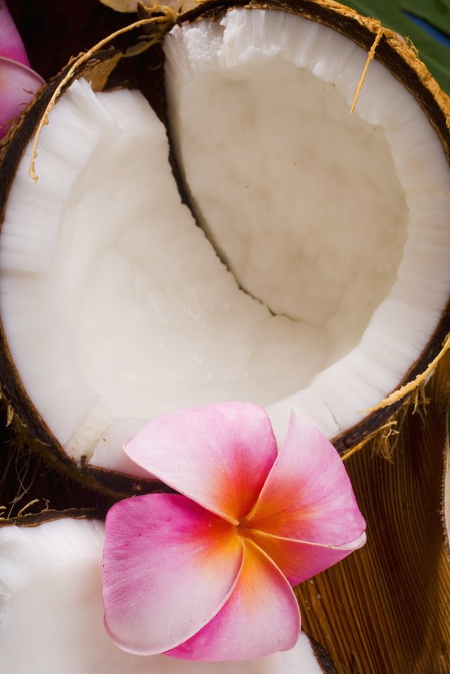 A coconut in halves, white meaty fruit with flowers
