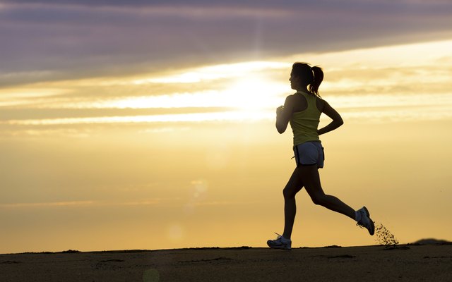 Athlete running at sunset on beach