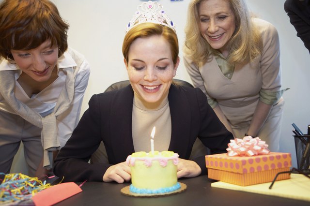 Businesswoman celebrating birthday with colleagues